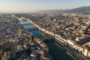 Luftaufnahme der Skyline von Florenz entlang des Flusses Arno bei Sonnenuntergang mit der Ponte Vecchio-Brücke im Vordergrund, Florenz, Toskana, Italien. - AAEF14166