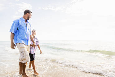 Vater und Sohn (10-11) gehen am Strand spazieren - TETF00502