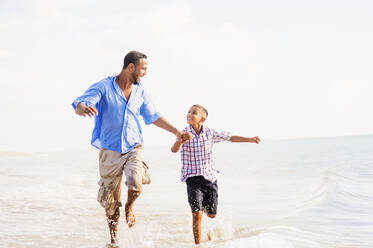 Vater und Sohn (10-11) laufen am Strand - TETF00503