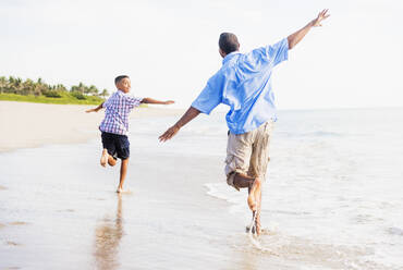 Vater und Sohn (10-11) laufen am Strand - TETF00504