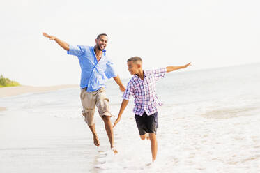 Vater und Sohn (10-11) laufen am Strand - TETF00505