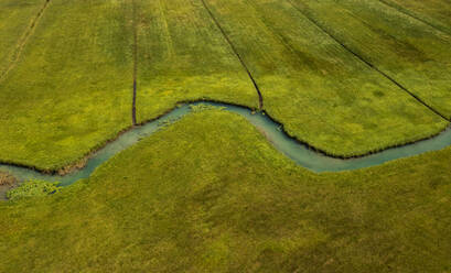 Drohnenansicht der Zeller Ache, die durch eine grüne Wiese fließt - WWF06163