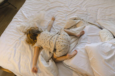 Mädchen mit ausgestreckten Armen zu Hause auf dem Bett liegend - SEAF00612