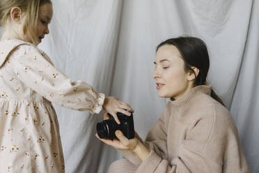 Daughter touching camera held by mother - SEAF00649