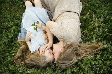 Smiling mother and daughter with eyes closed lying on grass - VBUF00038