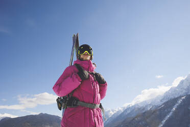 Mann in warmer Kleidung mit Skiern im Winter - OMIF00713