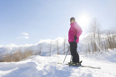 Mann in warmer Kleidung mit Skiern auf Schnee im Winter stehend - OMIF00727