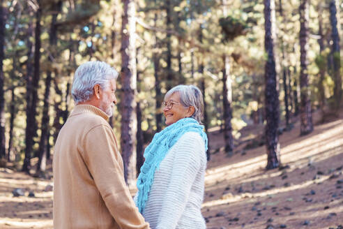 Happy senior couple looking at each other in forest - SIPF02772