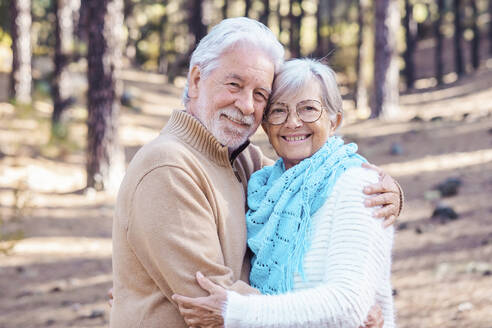 Glückliches älteres Paar umarmt sich im Wald - SIPF02774