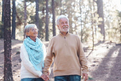 Happy senior man with woman in forest - SIPF02777