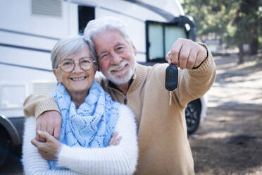 Glückliches älteres Paar mit Mann, der den Wohnmobilschlüssel zeigt - SIPF02788