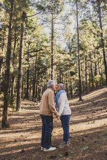 Senior couple kissing each other in forest - SIPF02797