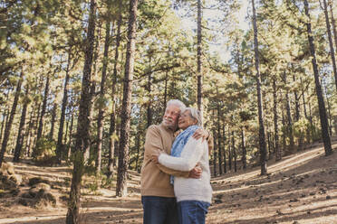 Glückliches älteres Paar, das sich im Wald umarmt - SIPF02798