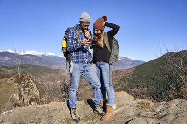 Girlfriend and boyfriend sharing smart phone on sunny day - VEGF05323