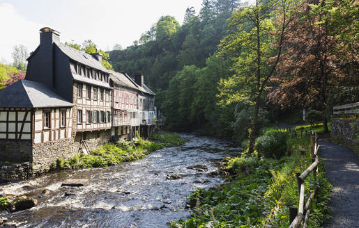 Germany, North Rhine-Westphalia, Monschau, Historic half-timbered townhouses standing on bank of Rur river in spring - GWF07365