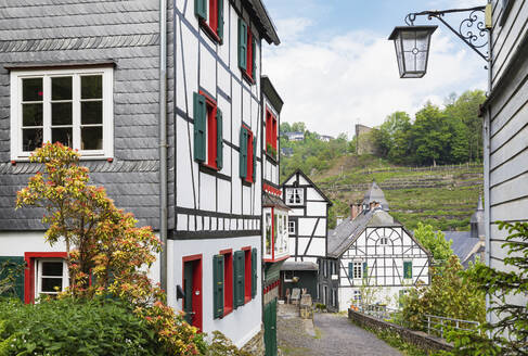 Germany, North Rhine-Westphalia, Monschau, Half-timbered townhouses along street in medieval town - GWF07372