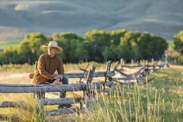 USA, Idaho, Bellevue, Rancher lehnt an Zaun auf Feld - TETF00623