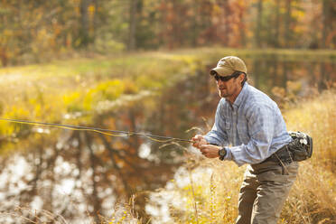 Mann beim Fliegenfischen im Fluss im Herbst in Giles County, Virginia, USA - TETF00652