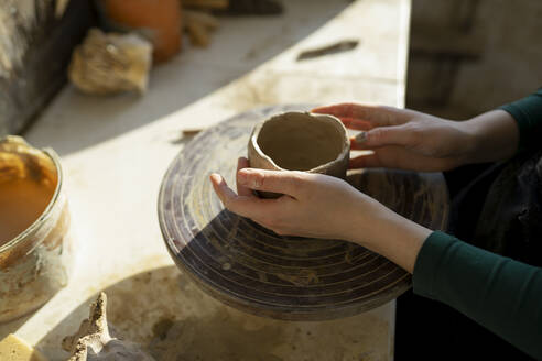 Hands of woman molding clay on potter's wheel - TETF00661