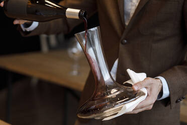 Kellner gießt Rotwein in eine Karaffe - TETF00706