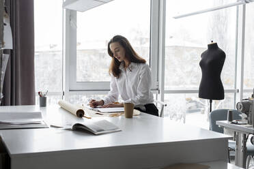 Modedesigner bei der Arbeit am Schreibtisch im Atelier - TETF00707