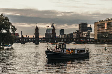 Illuminated boat on river at dusk - MJRF00644