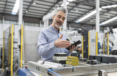 Entwickler besprechen die Maschine per Videoanruf auf einem Tablet-PC in der Fabrik - JCCMF05552