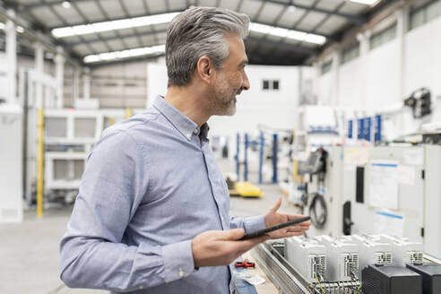 Ingenieur mit Tablet-PC in der Fabrik stehend - JCCMF05554