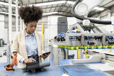 Businesswoman holding tablet PC working in factory - JCCMF05620