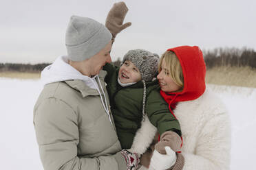 Happy parents carrying son enjoying in winter - SEAF00692