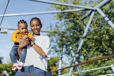 Happy young woman with cute daughter at park on sunny day - PGF01019