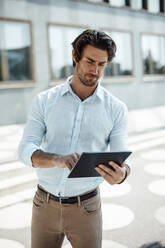 Geschäftsmann mit Tablet-PC an einem sonnigen Tag - GUSF07129