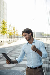 Geschäftsmann mit Tablet-PC vor einem Bürogebäude - GUSF07151