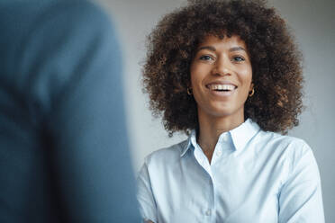 Smiling businesswoman by colleague at work place - JOSEF07413