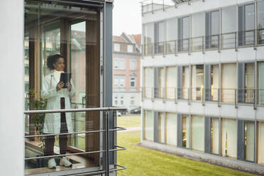 Doctor with tablet PC seen through window of hospital - JOSEF07430