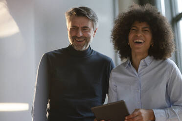 Multiracial business people laughing at work place - JOSEF07442