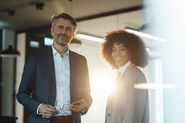 Smiling businessman with colleague in office - JOSEF07529