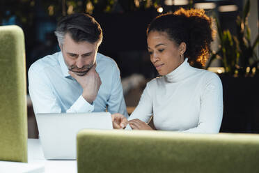 Multirassische Geschäftskollegen diskutieren über Laptop im Büro - JOSEF07541