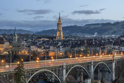 Switzerland, Canton of Bern, Bern, Kornhausbrucke bridge at dusk with bell tower of Cathedral of Bern in background - KEBF02253