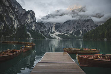 Italy, Wooden boats moored by pier at Pragser Wildsee in Dolomites - TETF00796