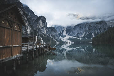 Italy, Wooden houses and pier at Pragser Wildsee in Dolomites - TETF00797