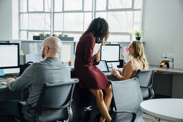 Mitarbeiter sprechen am Schreibtisch im Büro - TETF00861