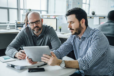 Männer benutzen ein digitales Tablet während einer Besprechung im Büro - TETF00867