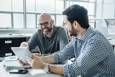 Männer benutzen ein digitales Tablet während einer Besprechung im Büro - TETF00868