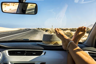 Weibliche Füße auf dem Armaturenbrett während einer Autofahrt - TETF00886