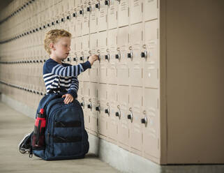 Boy with backpack by school lockers - TETF01025