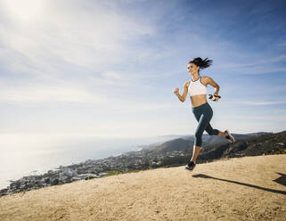 Frau joggt mit Wasserflasche auf einem Berg - TETF01026