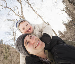 Young man carrying his son (12-17 months) on shoulders - TETF01034