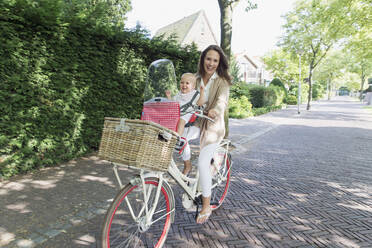 Mother with her baby daughter (12-17 months) on bicycle - TETF01084