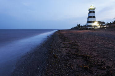 Illuminated West Point Lighthouse seen from empty beach - TETF01131